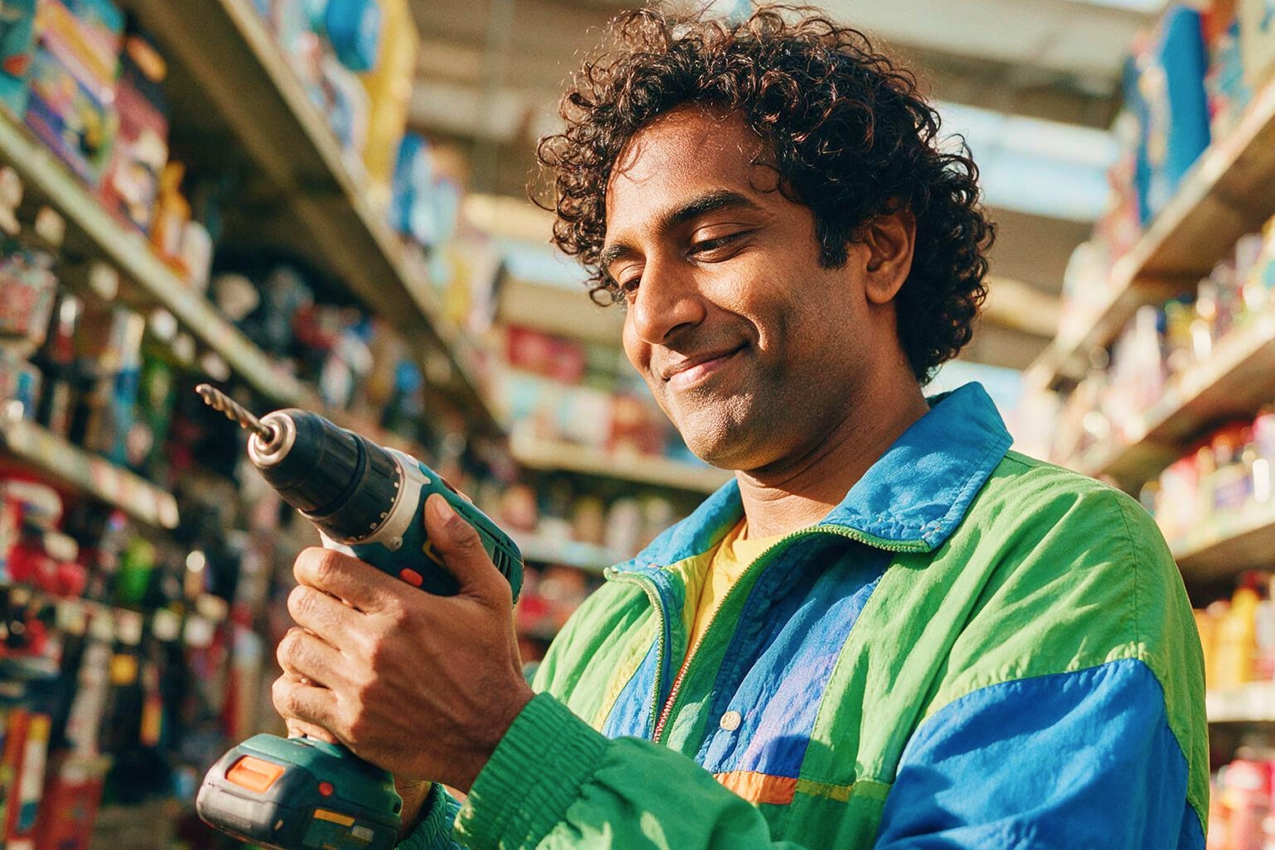 a young man is using a drill in a supermarket