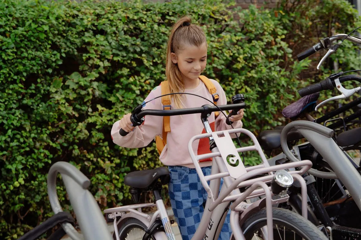 meisjes plaatst een cortina u4 transport mini in een fietsenstalling