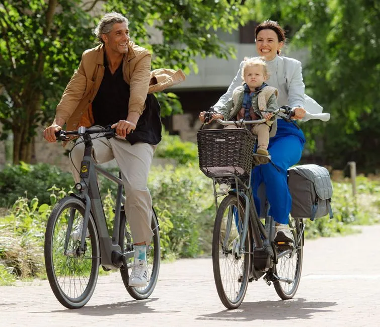 vrouw fietsend met kind op een cortina e-u4 transport familiefiets met naast haar een man fietsend op een cortina e-blau