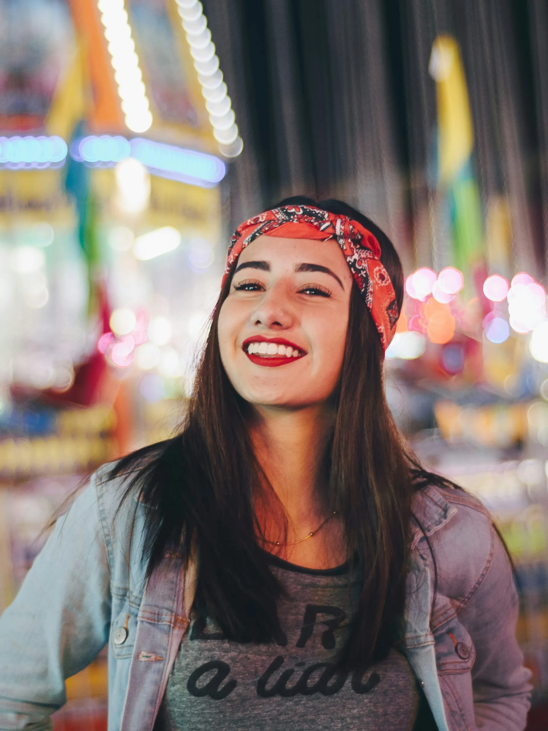 selective focus photography of smiling woman wearing red and black bandana