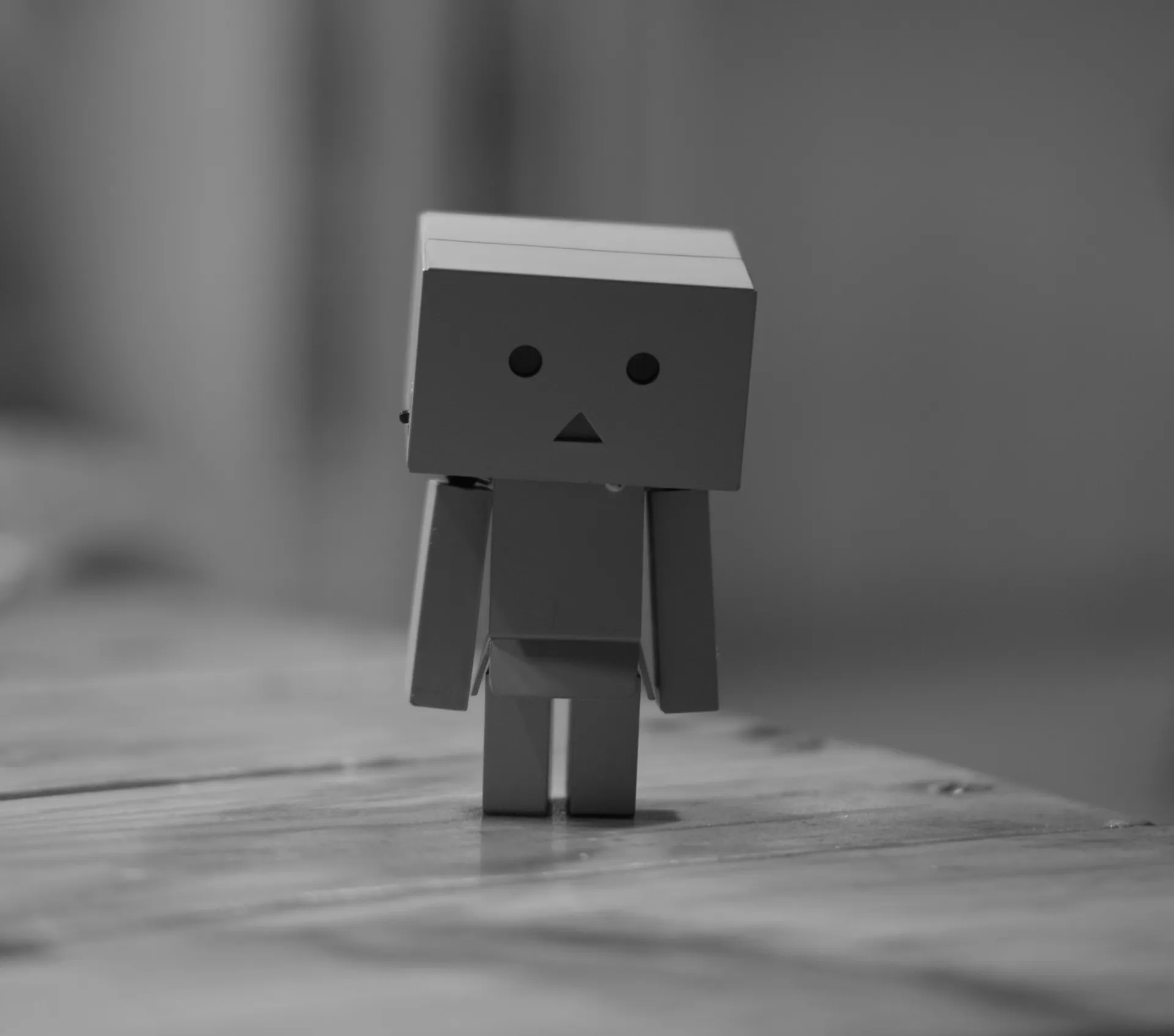 grayscale photo of box robot on table